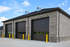 A large brick building with brown garage doors.