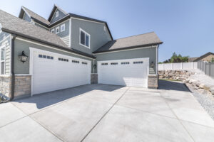 Garage Door Company Franklin TN Exterior of a house with concrete driveway and two closed white garage doors with windows