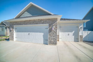 Garage Door Company Green Hills TN Three-car side hinged garage doors with stone veneer wall siding