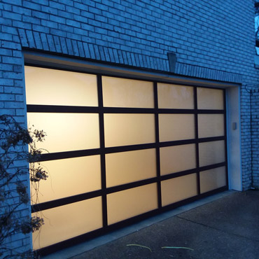 Modern residential garage with a black frame and frosted glass.