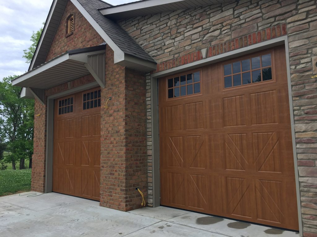 Residential home with brick siding and brown garage doors.