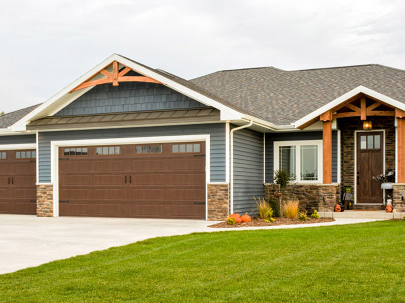 Single story home with blue-grey siding and brown garage doors.