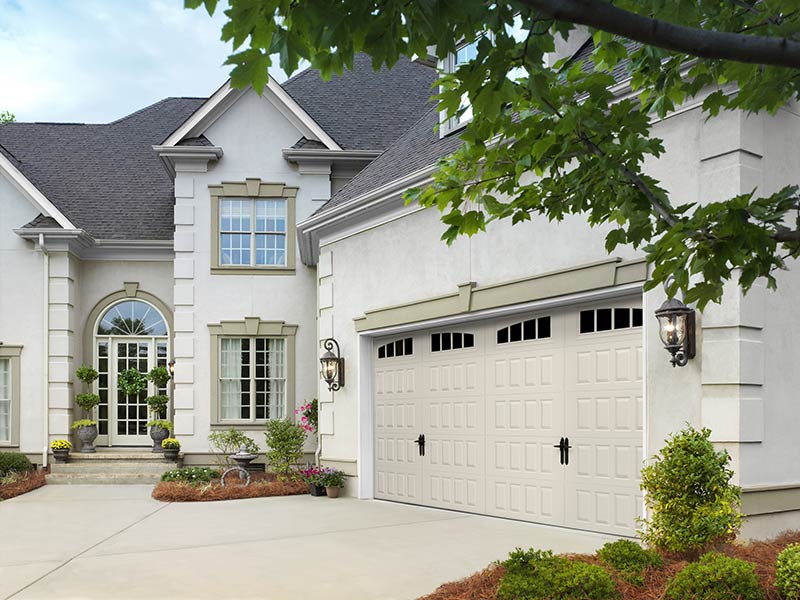 Beautiful Victorian-style home with white siding and cream-colored garage doors.