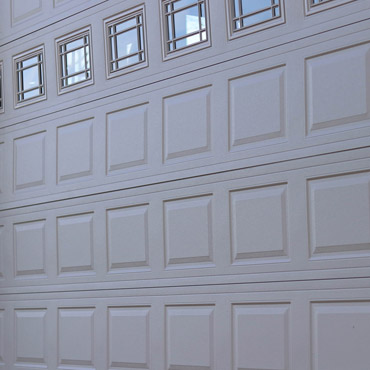 A gray sectional garage door with glass accents.