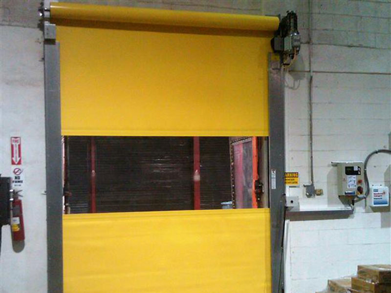 A yellow rolling garage door in a commercial warehouse.