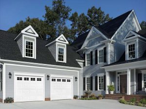 Residential Garage Door Repair Green Hills TN A luxury home with gray siding, brown roofing, and a paved driveway